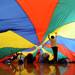 Elementary school children play under a colorful parachute during the 14th Annual Kids' Fair at University of Michigan on Friday. Melanie Maxwell I AnnArbor.com